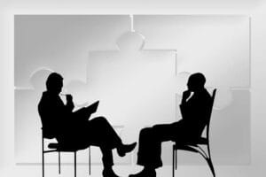 Silhouetted figures of an attorney and client discussing a personal injury case, symbolic of the client-focused approach at Hansen & Harmon Injury Law firm