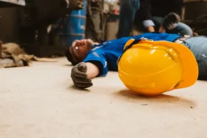 Construction accident victim unconscious on floor near hard hat
