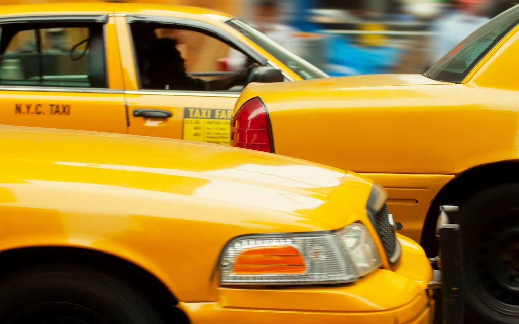 Taxis on busy roadway by Hansen & Harmon Injury Law